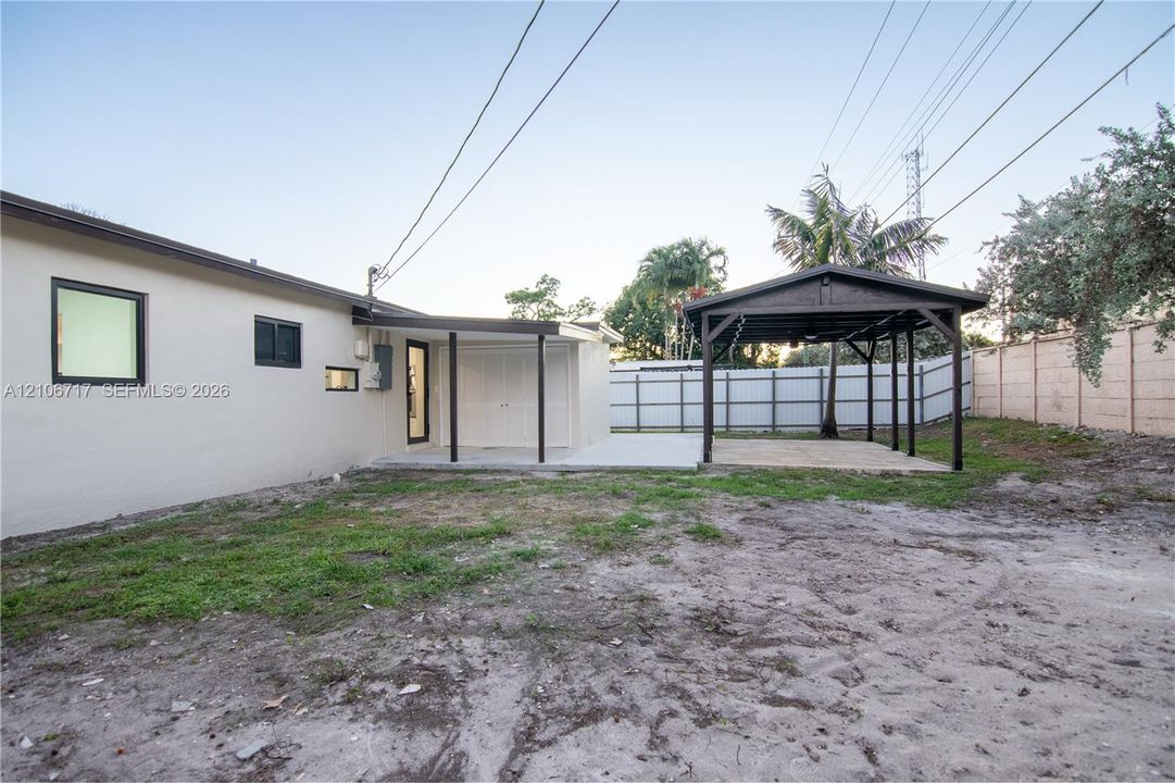 Backyard featuring a covered patio, a detached timber-framed pavilion, and a solid perimeter wall