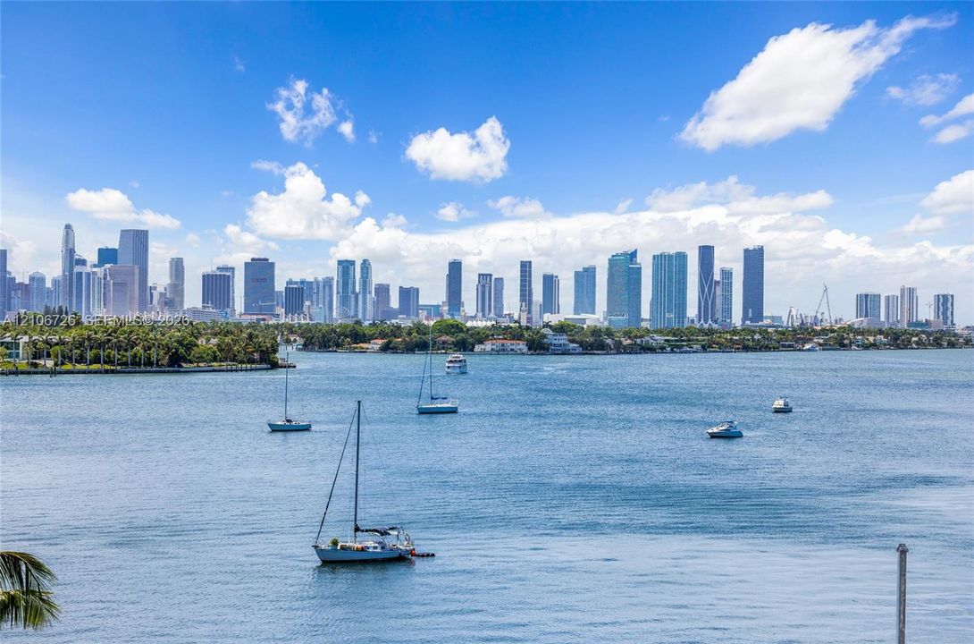 Waterfront perspective featuring deep-water bay, nautical activity, and expansive metropolitan skyline