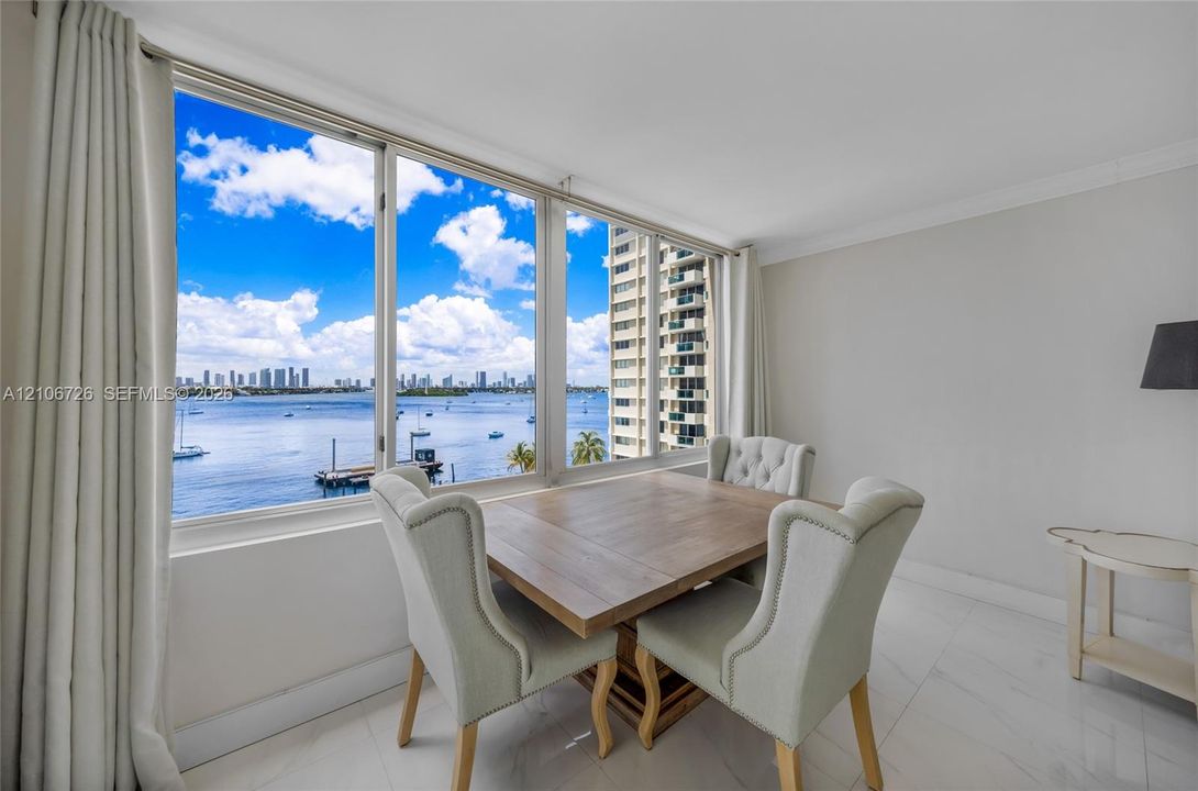 Large floor-to-ceiling windows, polished tile flooring, and expansive water and skyline scenery