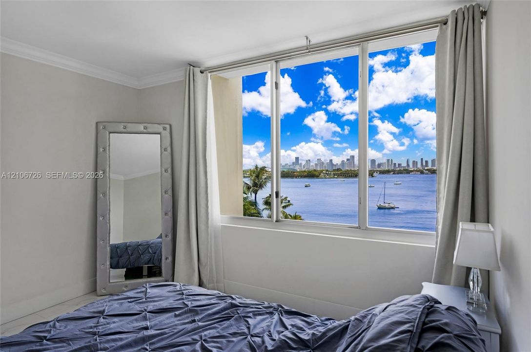 Expansive multi-pane window featuring a city skyline and water backdrop, complemented by crown molding and neutral-toned wall finish