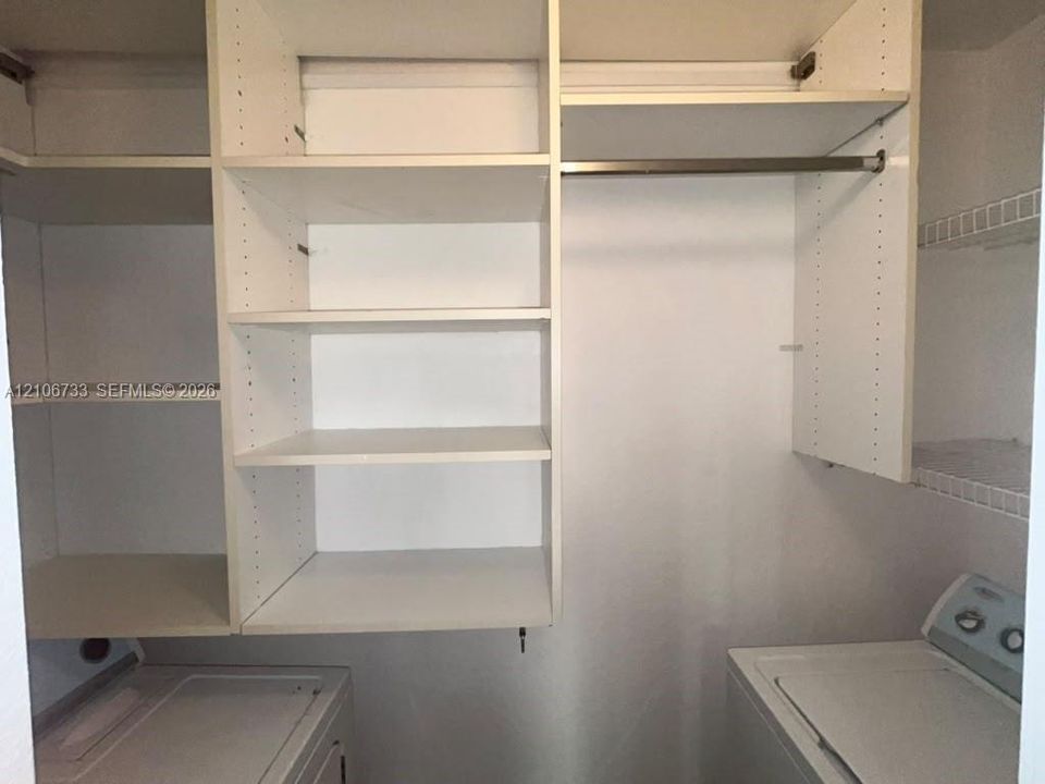 Built-in white storage cabinetry featuring adjustable shelving, integrated metal hanging rod, and wire shelving racks