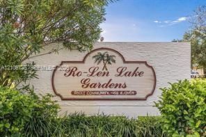 Community entrance monument featuring textured masonry signage and mature perimeter landscaping