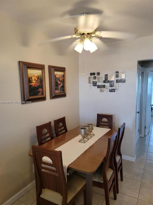 Ceiling-mounted fan with three-light fixture and neutral tile flooring