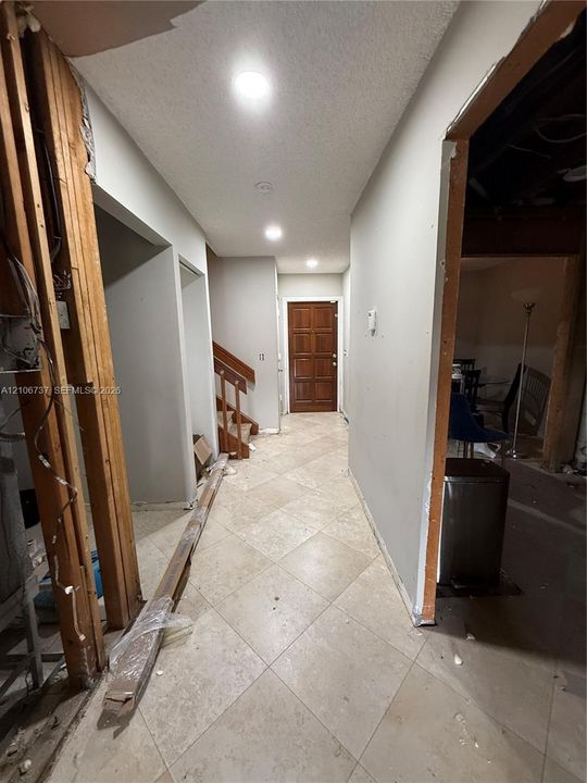 Interior entry featuring tile flooring, recessed lighting, and a paneled wooden front door