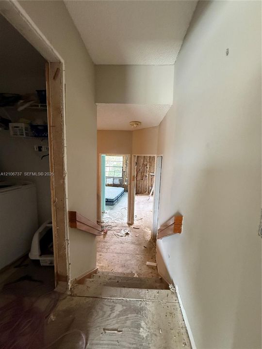 Interior staircase featuring wood-finish handrails and exposed subflooring