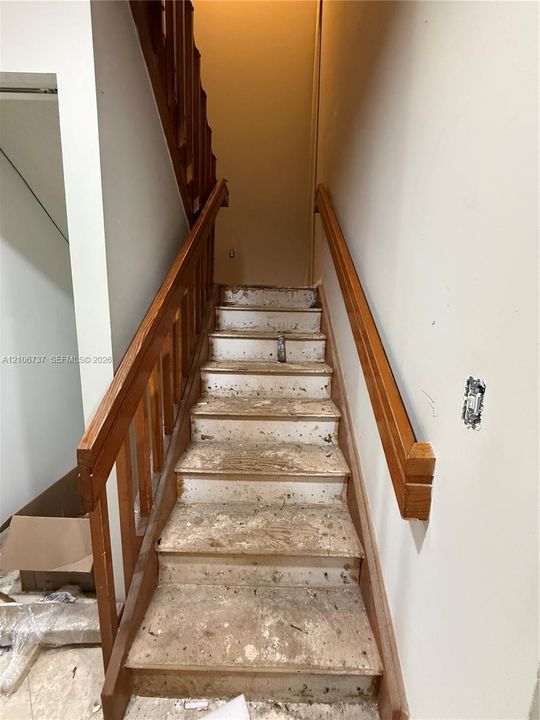 Staircase featuring wood handrails and balusters