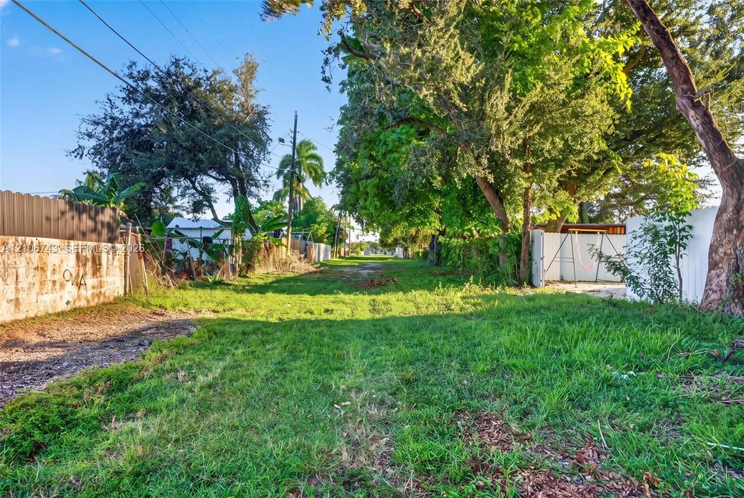 Expansive parcel of land featuring mature trees, masonry perimeter walling, and vinyl fencing