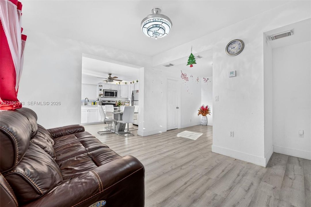 Wood-finish flooring, flush-mount decorative ceiling light fixture, and white cabinetry