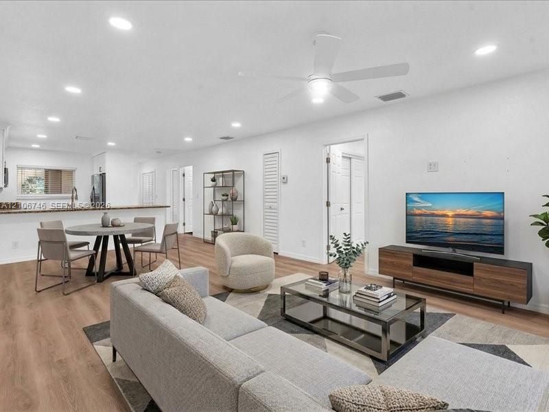 Open-concept interior featuring wood-finish flooring, recessed lighting, and a neutral color palette