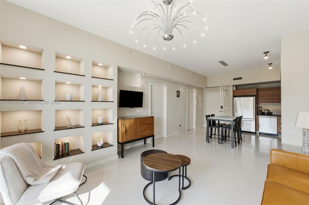 Living space featuring custom recessed wall shelving with integrated lighting