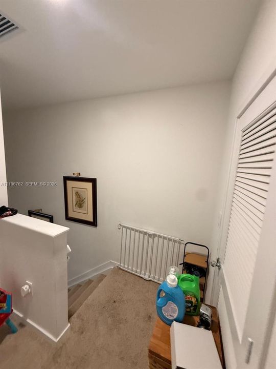 Neutral-toned wall-to-wall carpeting and louvered closet door