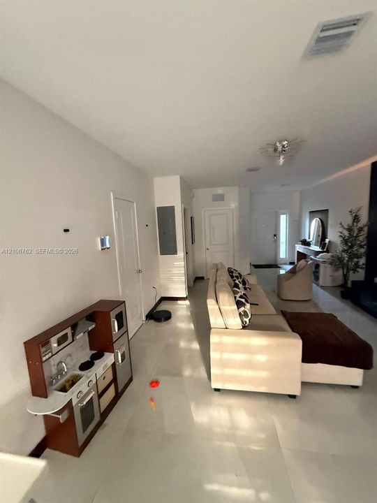 Large-format neutral tile flooring and recessed ceiling lighting