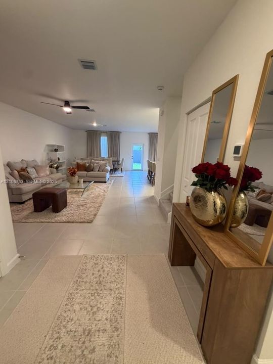 Open-concept interior featuring large-format ceramic tile flooring, neutral wall tones, recessed lighting, and a ceiling fan