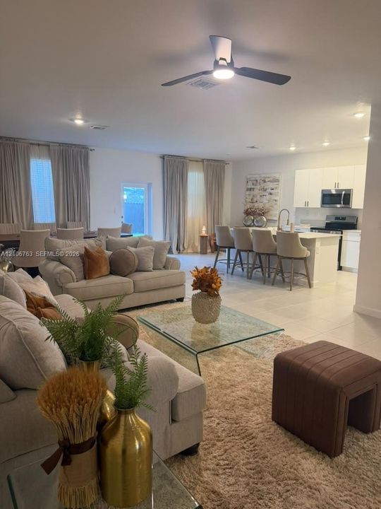 Open-concept living space featuring large-format tile flooring, recessed lighting, and a modern ceiling fan