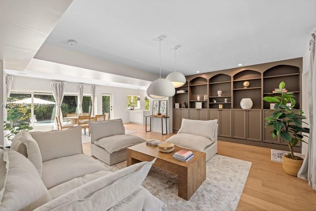 Built-in floor-to-ceiling cabinetry with arched shelving, wood-finish flooring, recessed lighting, and dual dome-style pendant fixtures