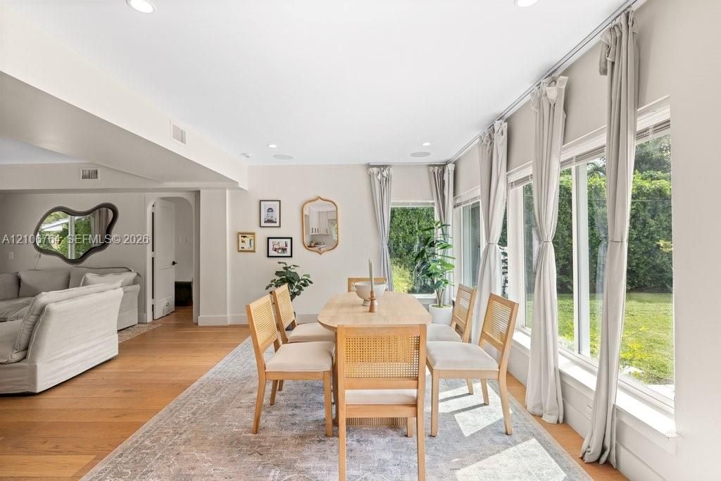 Dining area featuring wood-finish flooring, recessed lighting, and expansive wall-to-wall windows
