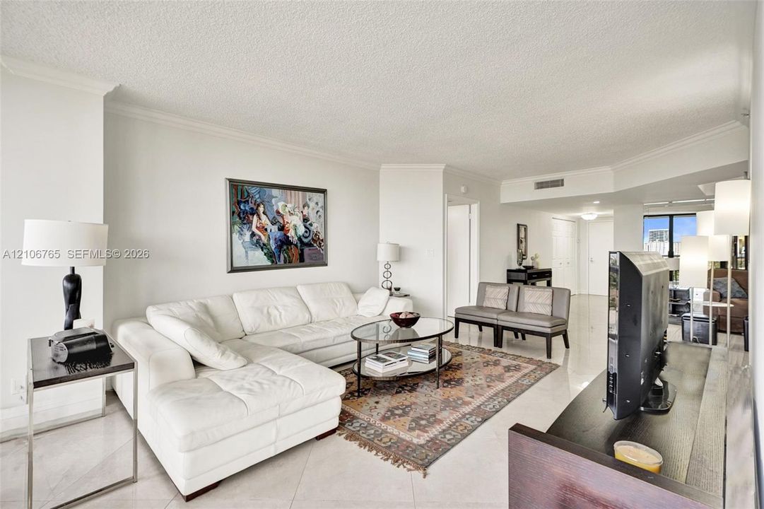 Open-concept living space, ceramic tiles, neutral wall tones.