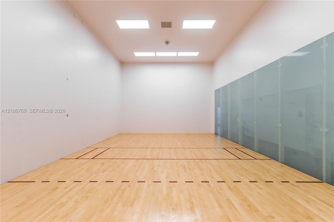 Recreation court featuring wood-finish flooring, high ceilings, recessed lighting, and a glass wall panel