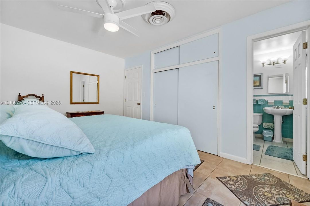 Interior space featuring tile flooring, ceiling fan with integrated lighting, and floor-to-ceiling sliding closet doors