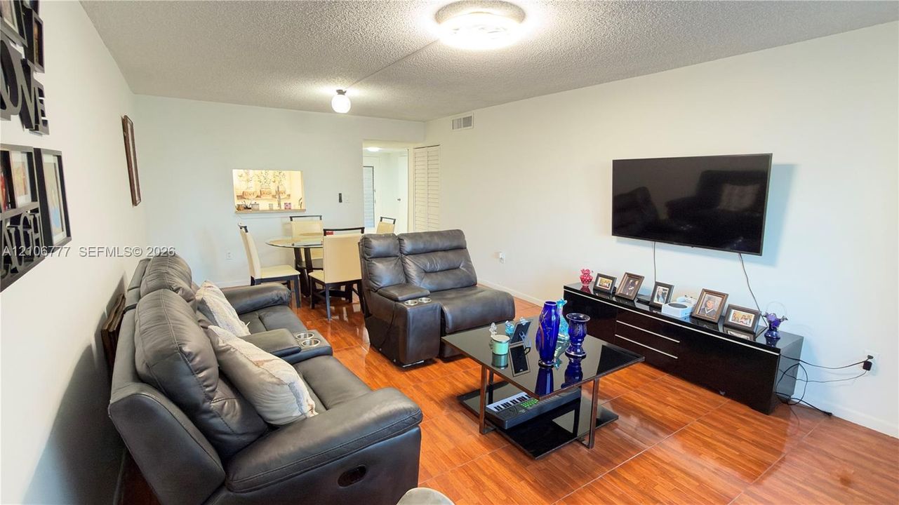 Living area featuring wood-finish flooring, neutral wall tones, and recessed ceiling lighting