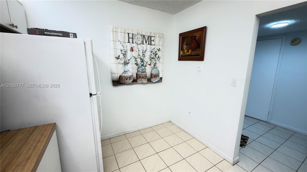 Kitchen featuring white cabinetry, wood-finish countertops, and ceramic tile flooring