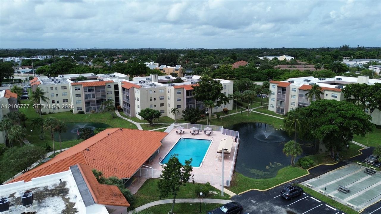 Community amenities include a swimming pool, two fountain-equipped ponds, landscaped grounds with mature trees, and an outdoor shuffleboard court