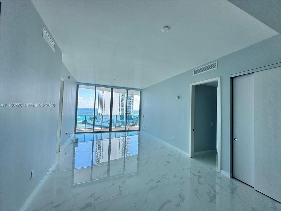 Floor-to-ceiling glass windows, polished stone-finish flooring, sliding door closet, and recessed lighting