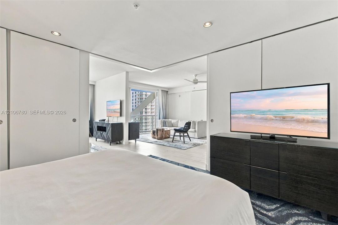 Floor-to-ceiling sliding panels, recessed ceiling lighting, and wood-finish flooring