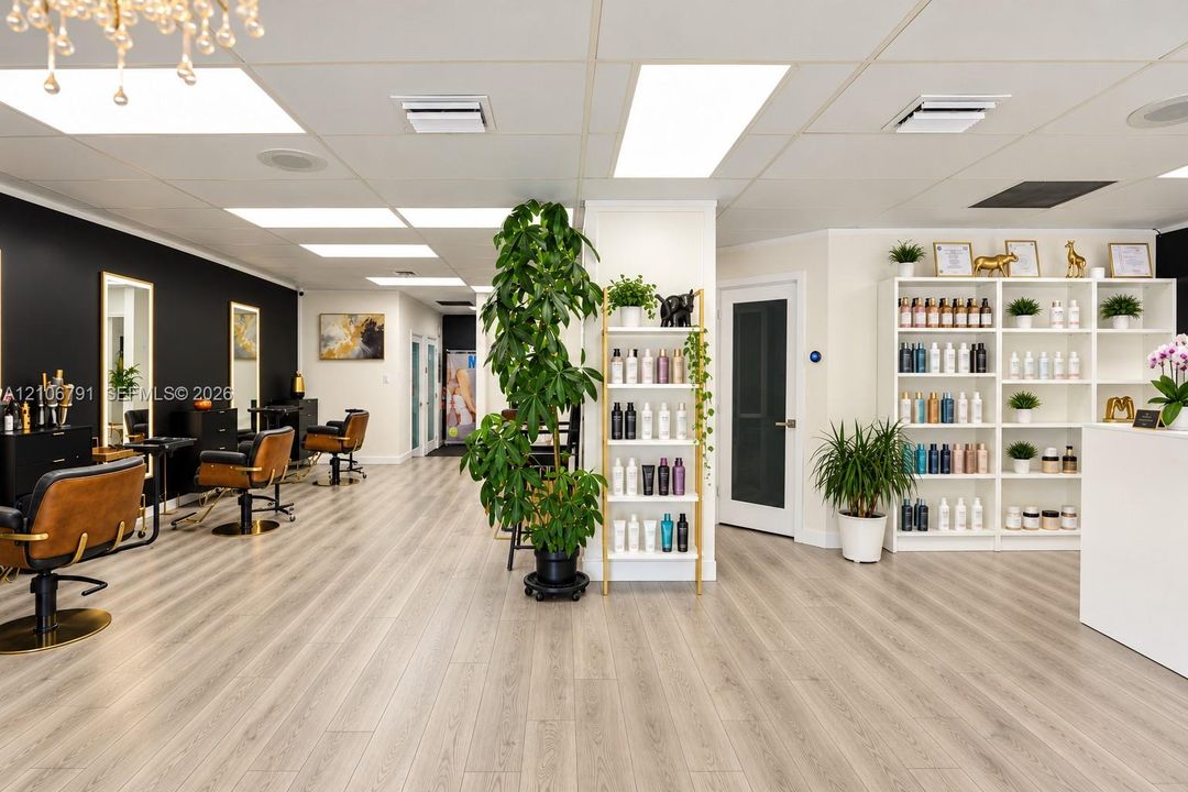 Commercial interior space featuring wood-finish flooring, recessed lighting, built-in open shelving, and a bold high-contrast accent wall