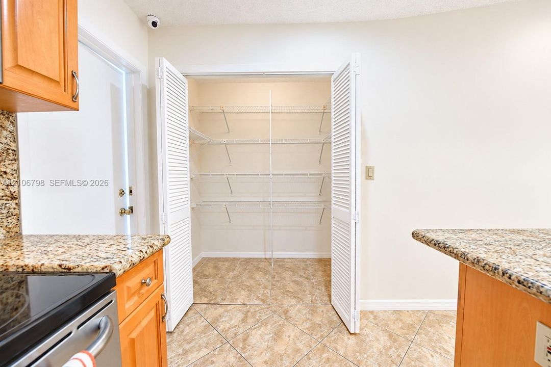 Walk-in pantry featuring white louvered bifold doors and integrated multi-level wire shelving