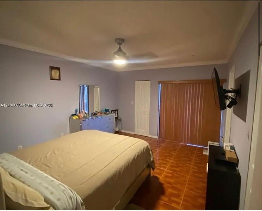 Ceramic tile flooring, crown molding, ceiling fan with integrated lighting, and vertical sliding glass doors