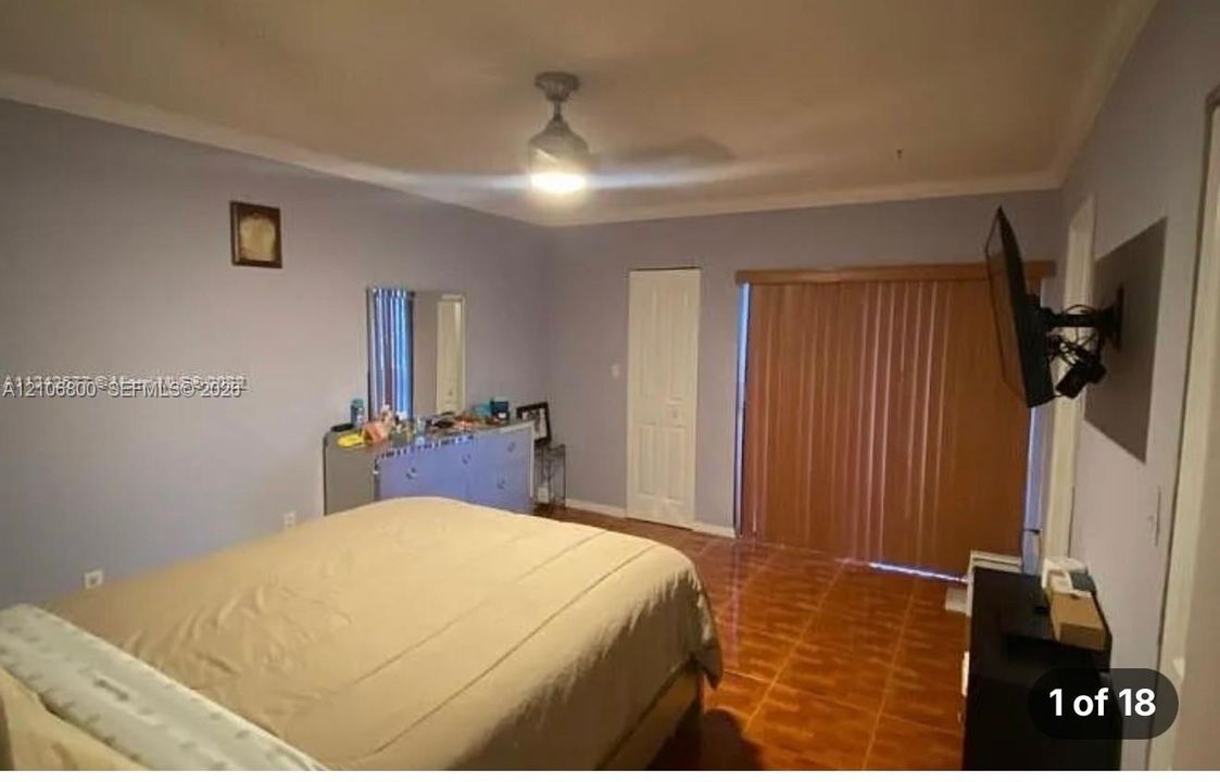 Interior room featuring ceramic tile flooring, a ceiling fan, and vertical blinds covering the door