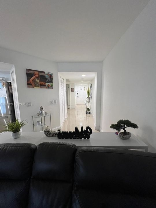 Interior hall featuring high-gloss tile flooring, recessed lighting, and multi-panel bi-fold doors