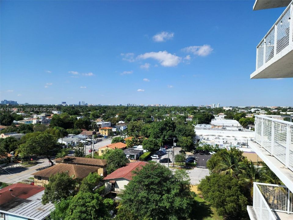 Elevated balcony featuring white metal railings and a panoramic perspective of the surrounding landscape