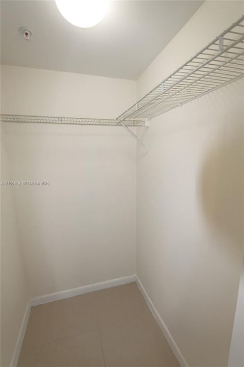 Storage area featuring wall-mounted wire shelving and tile flooring