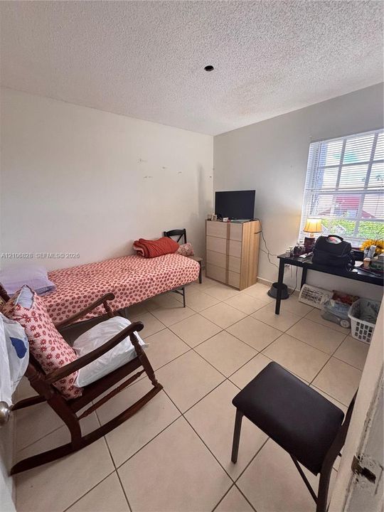 Room featuring ceramic tile flooring and a multi-pane window with interior blinds