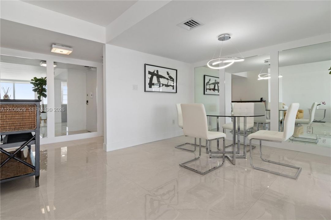 Polished tile flooring, wall-to-wall mirrored panels, and a modern circular LED pendant light fixture