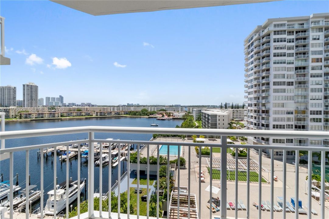 Elevated balcony with white powder-coated aluminum railing overlooking a marina and waterway