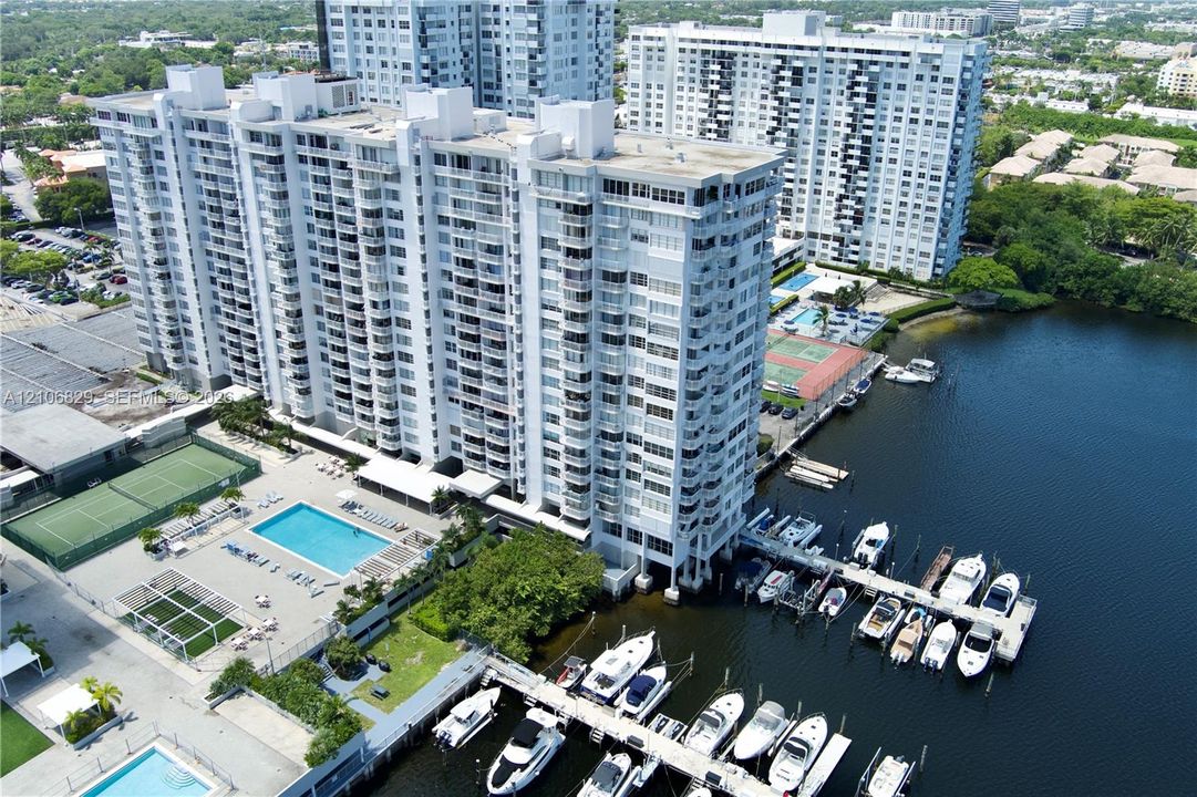 High-rise residential building featuring a swimming pool, tennis court, and private deep-water marina dockage