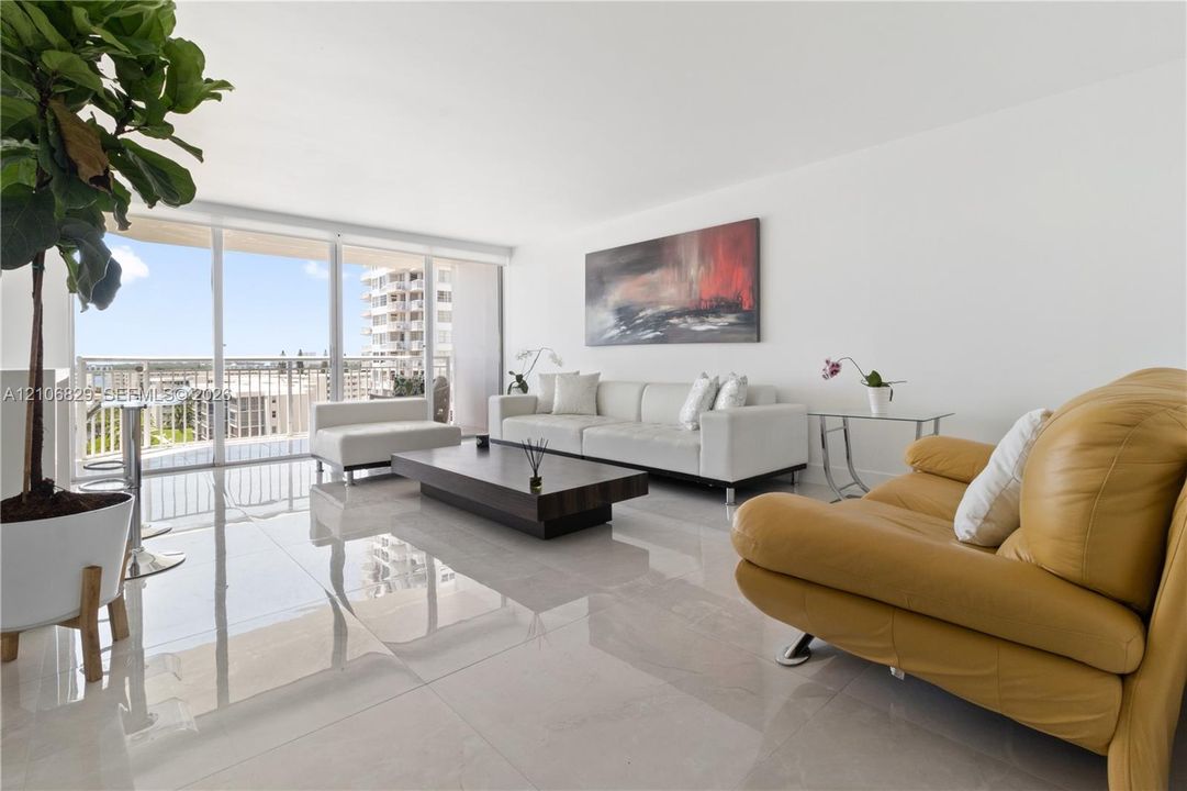 Large-format polished tile flooring, floor-to-ceiling glass sliding doors, and access to a private balcony