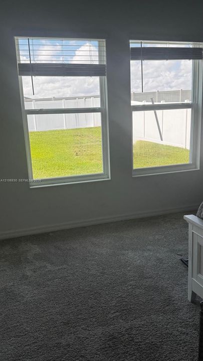 Dual energy-efficient windows, neutral wall coloring, textile flooring, and white vinyl perimeter fencing
