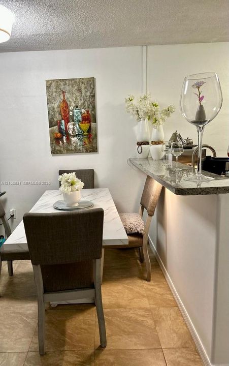 Stone-surface breakfast bar with under-counter lighting and tile flooring