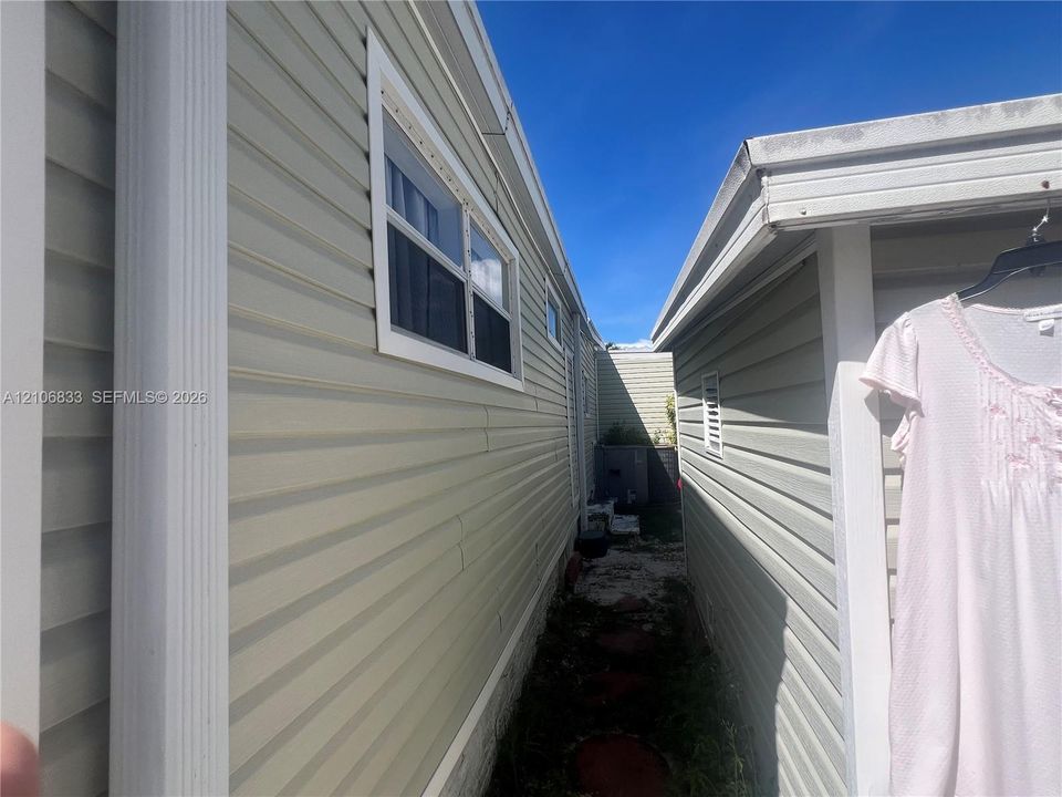 Vinyl horizontal siding exterior featuring white window trim, vertical corner molding, and integrated rain gutters