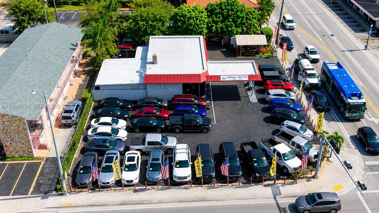 Commercial property featuring a flat-roof structure with a covered drive-through canopy and paved asphalt lot