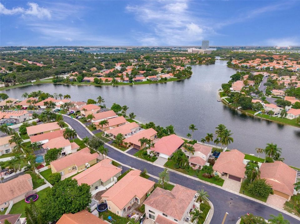 Aerial perspective of a waterfront residential community featuring tile roofing and expansive lake frontage