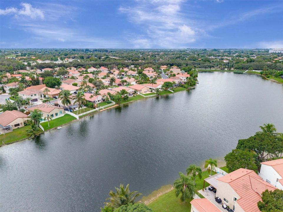 Aerial perspective featuring waterfront property, expansive lake frontage, and tropical landscaping