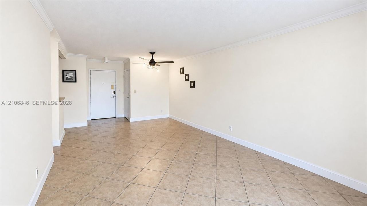 Neutral-toned interior featuring ceramic tile flooring, ceiling-mounted fan with integrated lighting, and smooth ceiling finish