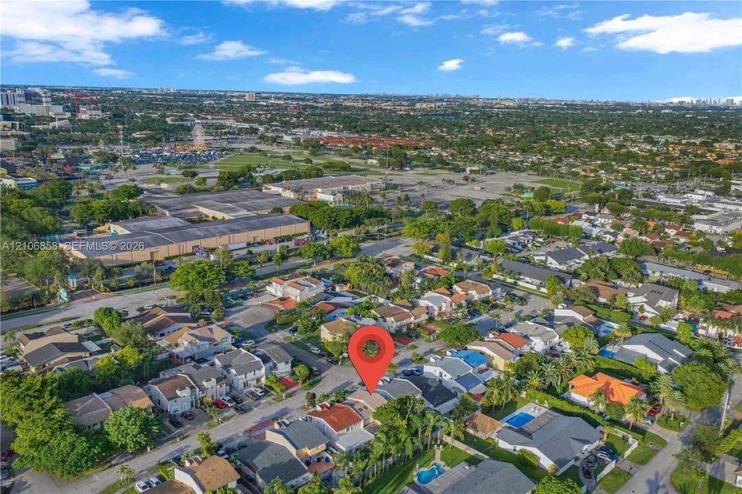 Aerial perspective of residential suburban neighborhood featuring varied rooflines, paved street access, and established tree canopy