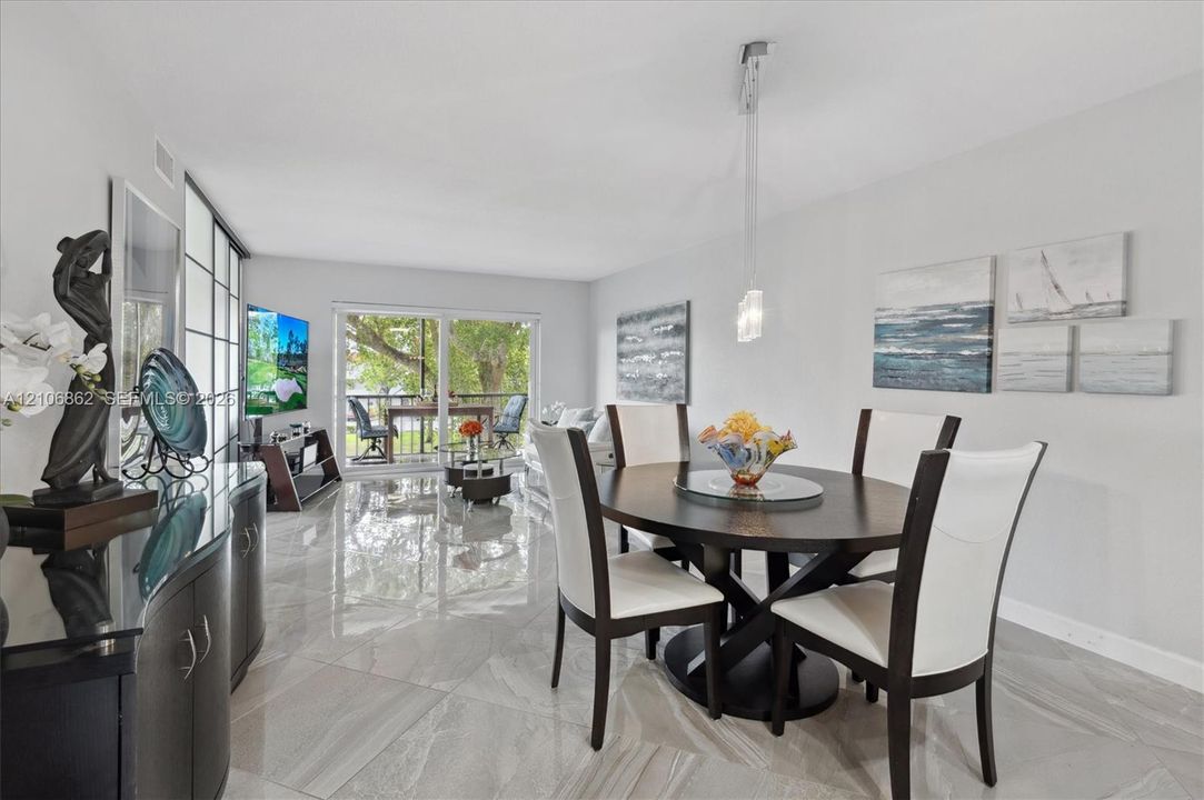 Open-concept area featuring polished tile flooring, sliding glass doors, and a modern pendant light fixture