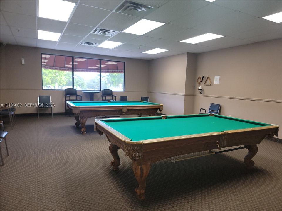 Spacious room featuring a drop ceiling with recessed lighting and carpeted flooring